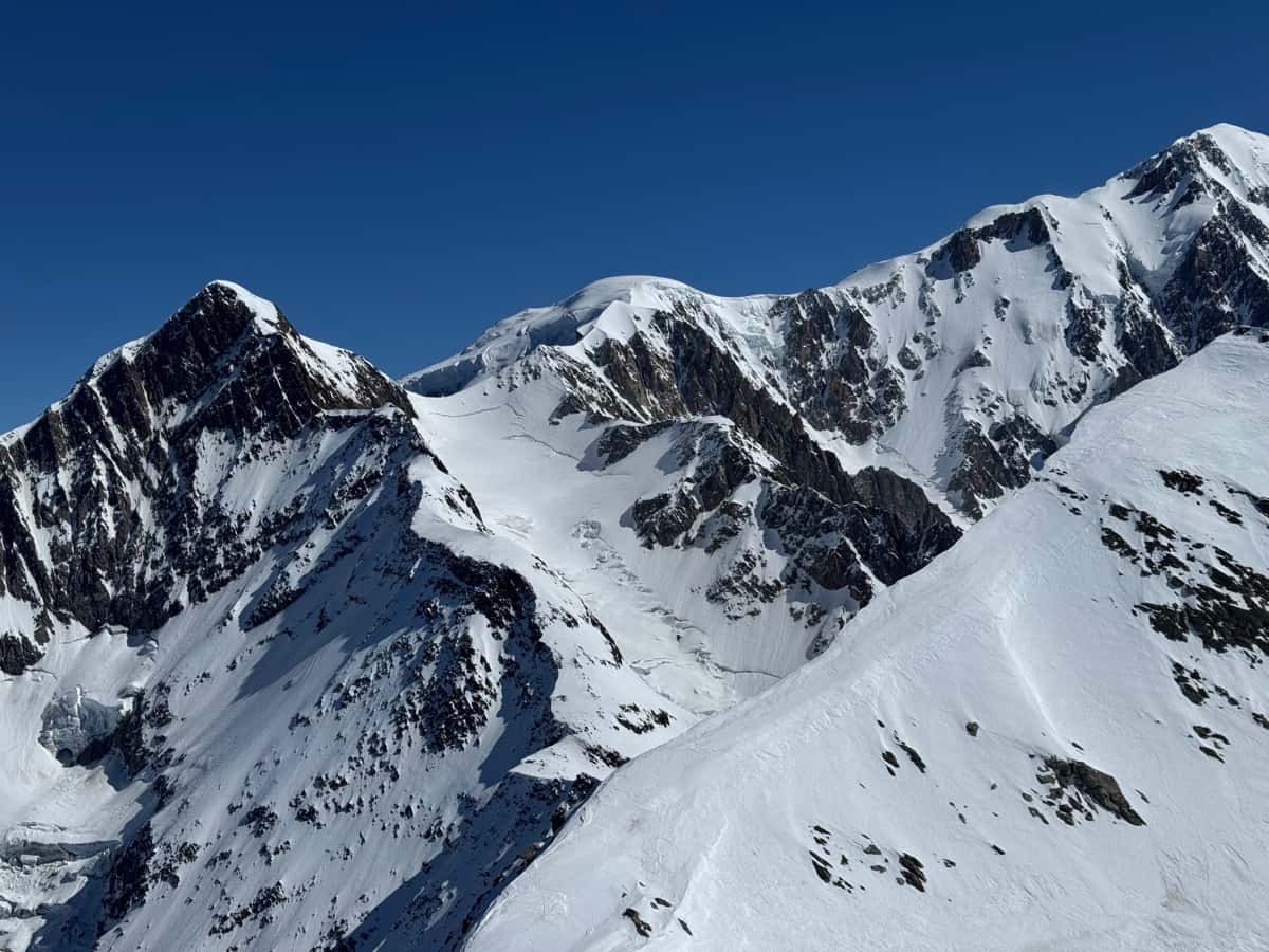 Pentes alpines chargées de neige avec des départs d'avalanche visibles