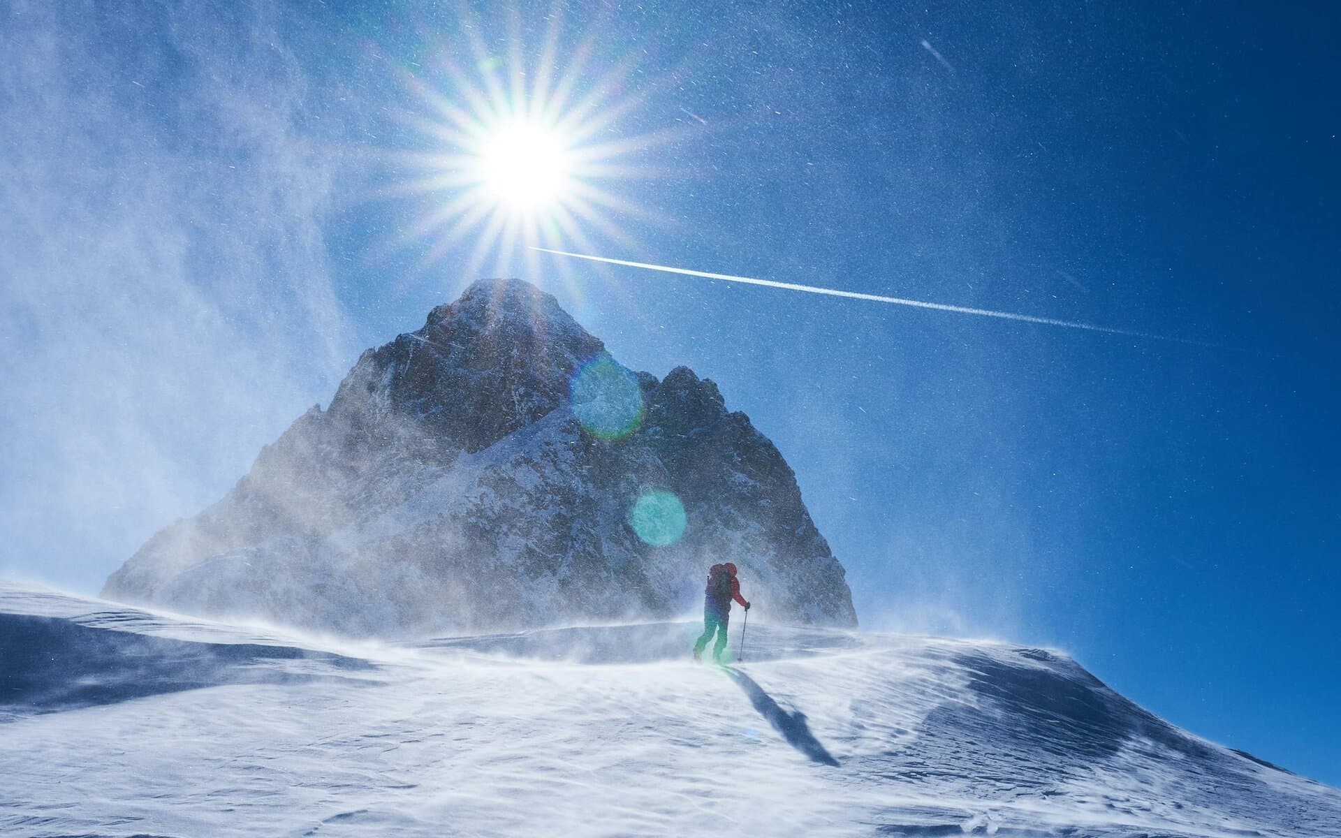Rider en montée dans un terrain alpin enneigé